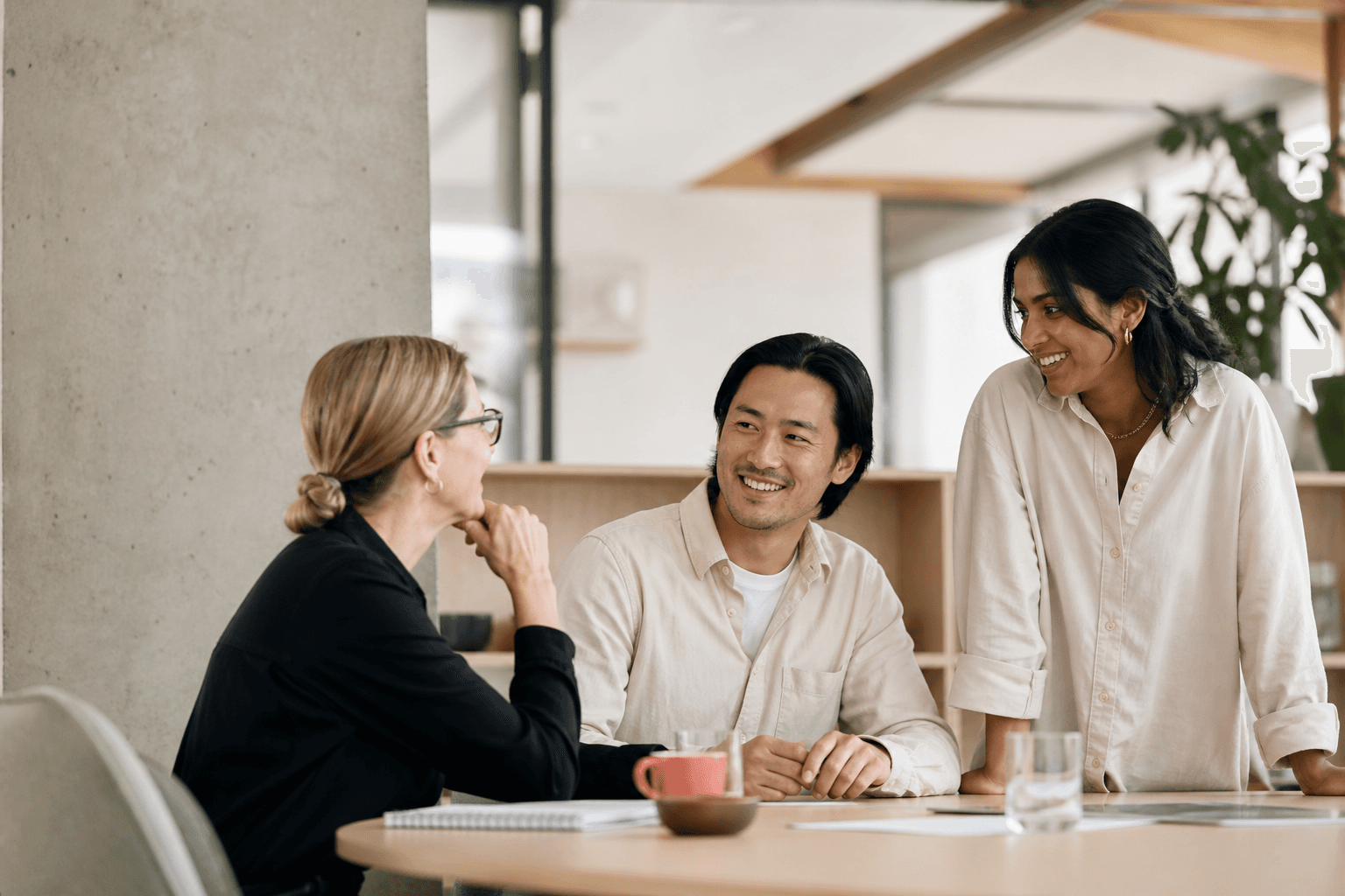 Three colleagues collaborating in a light-filled workplace